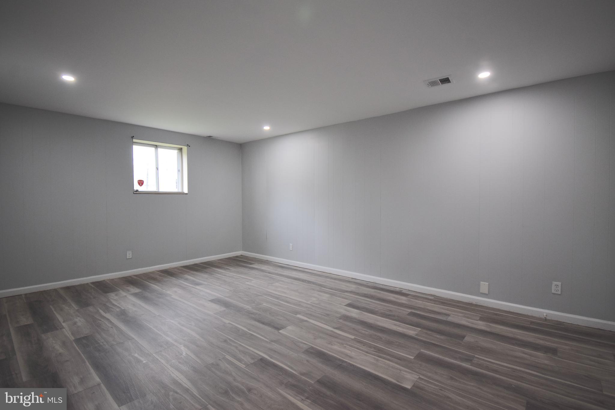 14017 Adkins Road Laurel, MD 20708 - Photo 11 of 19 an empty room with wooden floor and windows