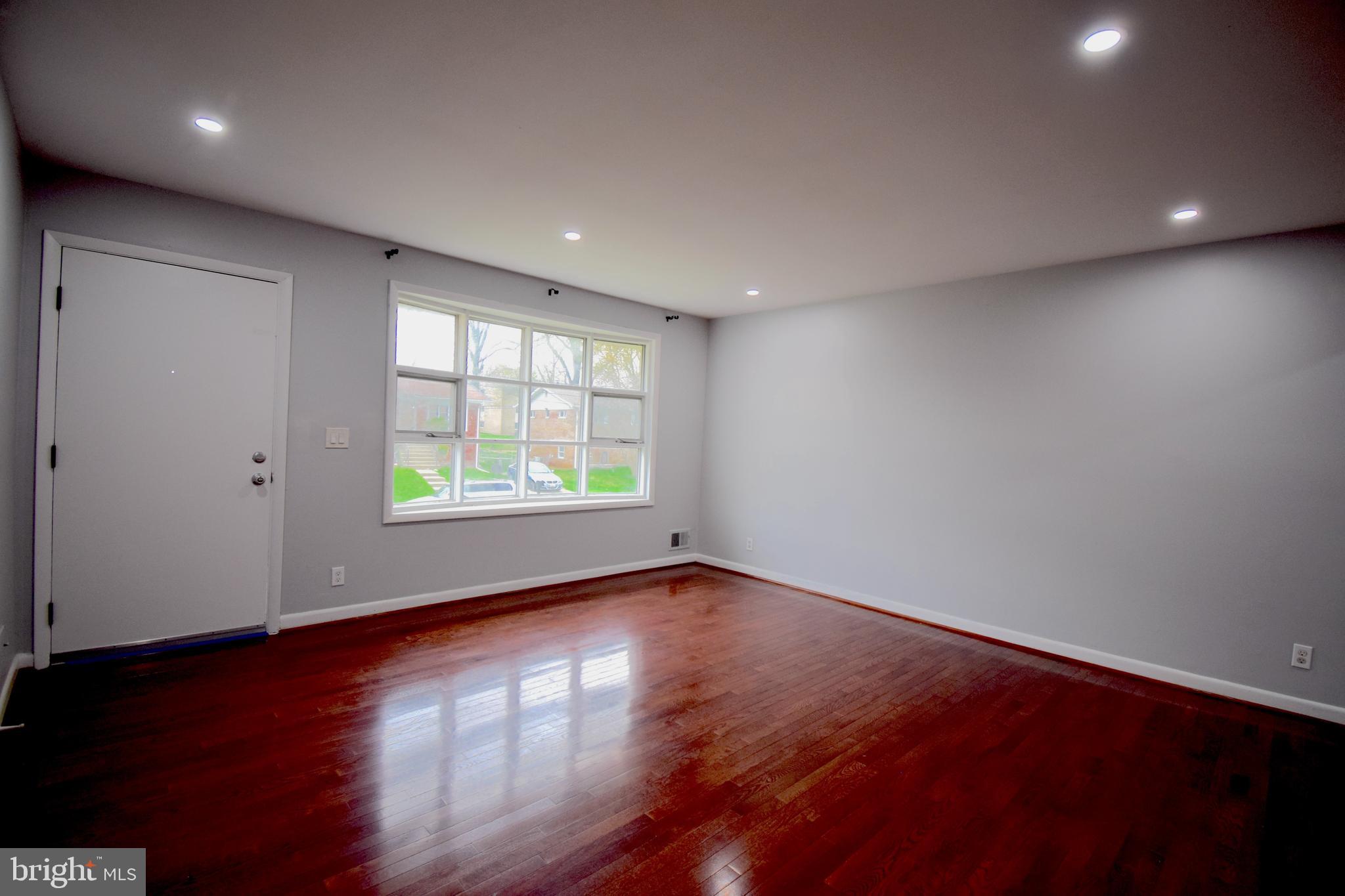 14017 Adkins Road Laurel, MD 20708 - Photo 7 of 19 an empty room with wooden floor and windows