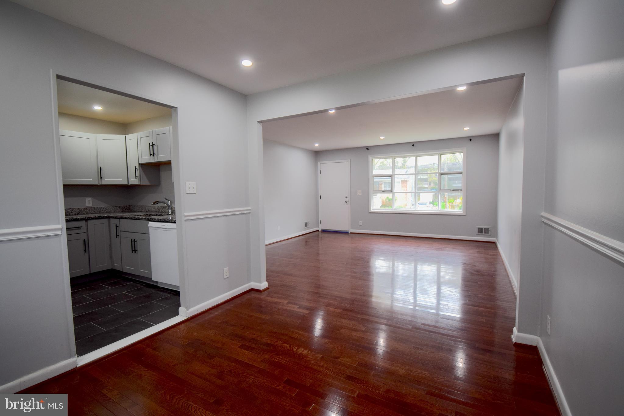 14017 Adkins Road Laurel, MD 20708 - Photo 9 of 19 a view of empty room with wooden floor and kitchen