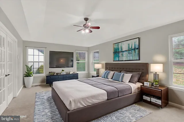 a bedroom with a bed a couch and large window