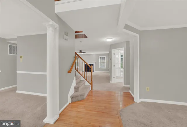 a view of a hallway with white walls and stairs
