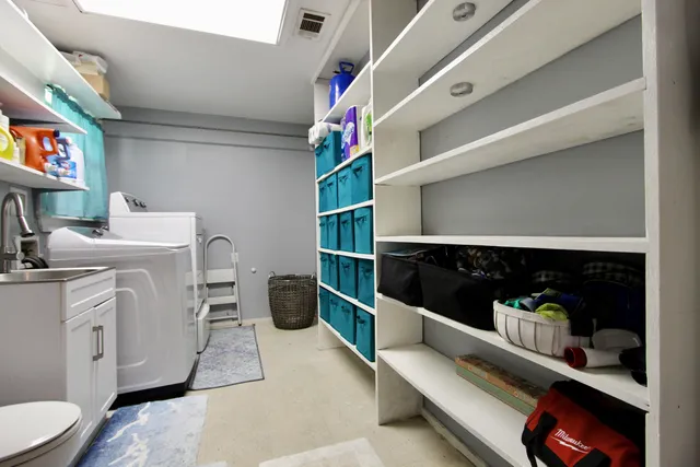 a utility room with sink dryer and washer
