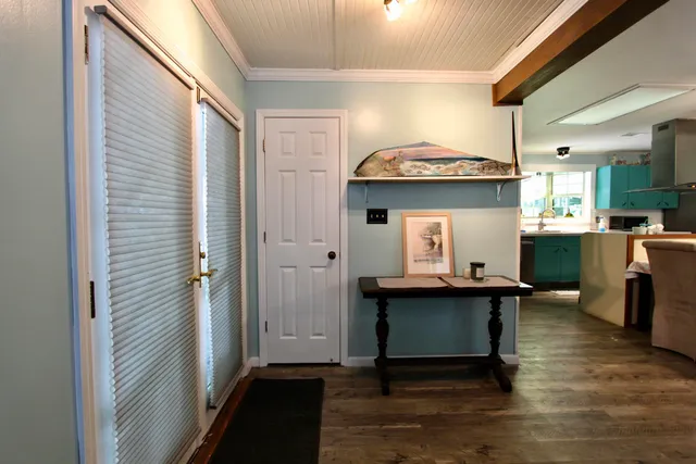 a view of a kitchen with kitchen island stainless steel appliances wooden floor