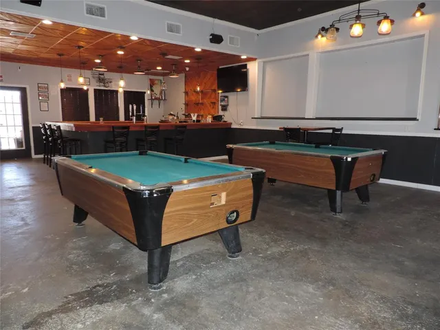 a room with pool table and windows
