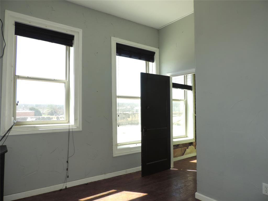 112 South Austin Street Ranger, TX 76470 - Photo 24 of 40 a view of an empty room with wooden floor and a window