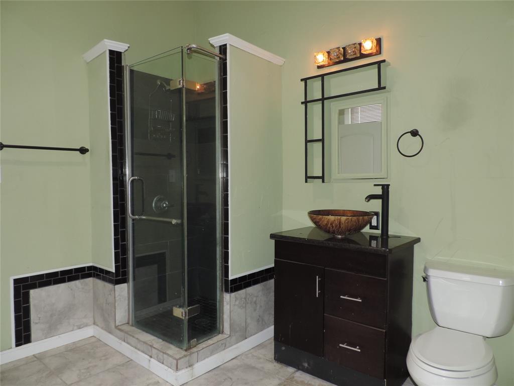 112 South Austin Street Ranger, TX 76470 - Photo 29 of 40 a bathroom with a toilet a sink and shower