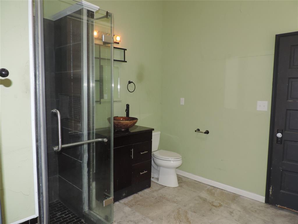 112 South Austin Street Ranger, TX 76470 - Photo 30 of 40 a bathroom with a granite countertop sink toilet and shower