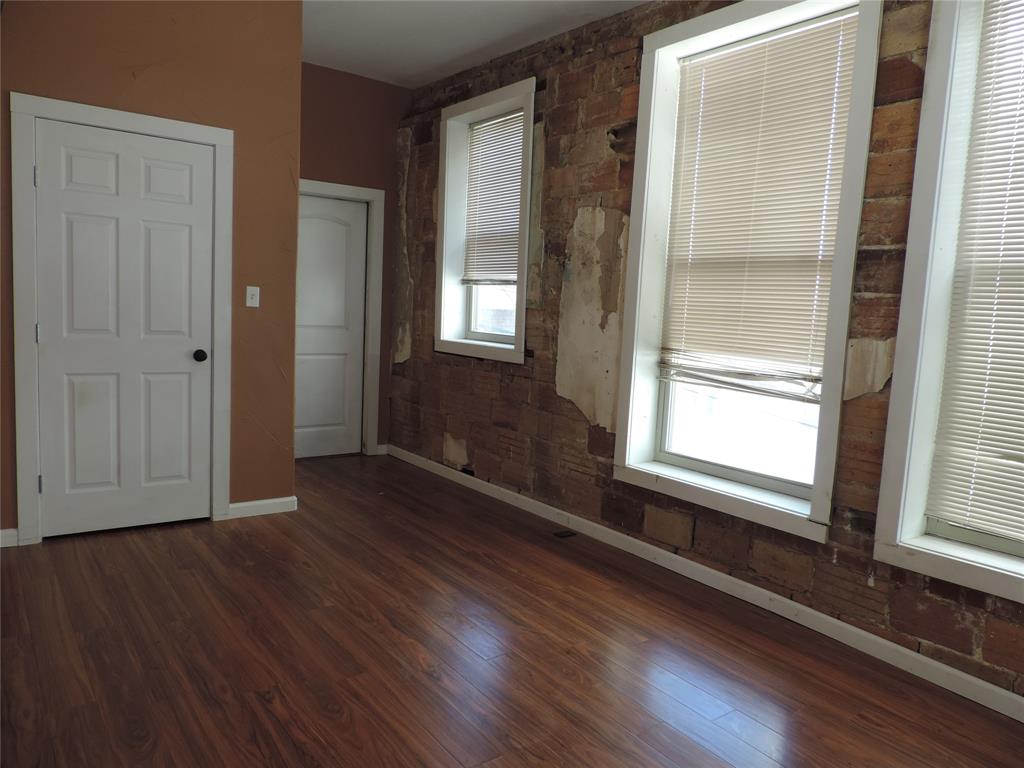 112 South Austin Street Ranger, TX 76470 - Photo 34 of 40 a view of an empty room with wooden floor and a window