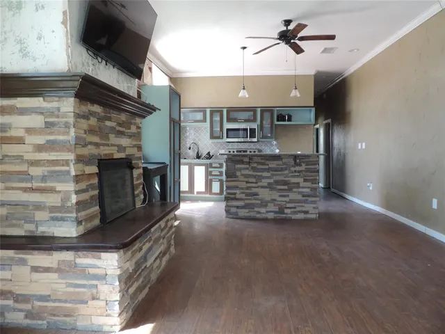a view of empty room with wooden floor and fireplace