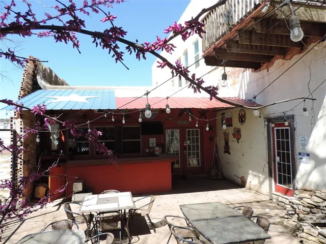 a view of a patio with table and chairs under an umbrella