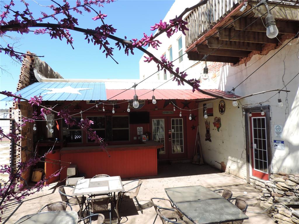 112 South Austin Street Ranger, TX 76470 - Photo 5 of 40 a view of a patio with table and chairs under an umbrella