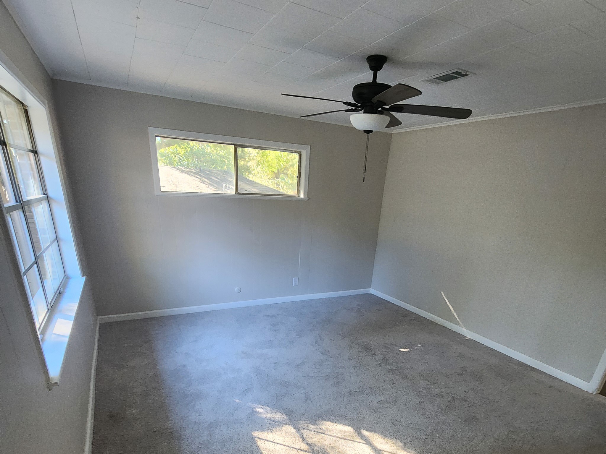 201 Verna Street Jasper, TX 75951 - Photo 14 of 27 This inviting primary bedroom offers ample natural light and a convenient ensuite, blending comfort and functionality effortlessly.