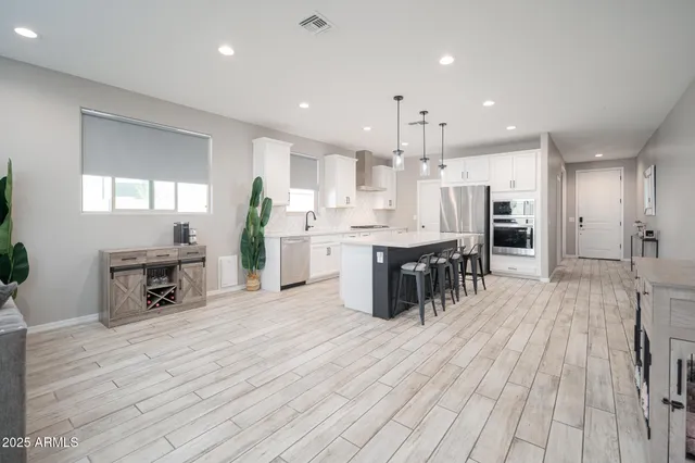 a large kitchen with stainless steel appliances kitchen island granite countertop a large cabinets a sink and a counter top space