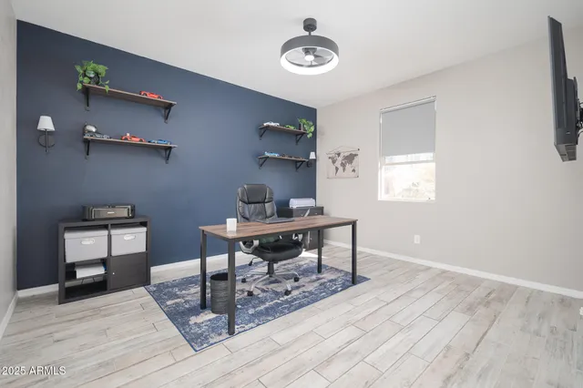 a view of a workspace with furniture and a window