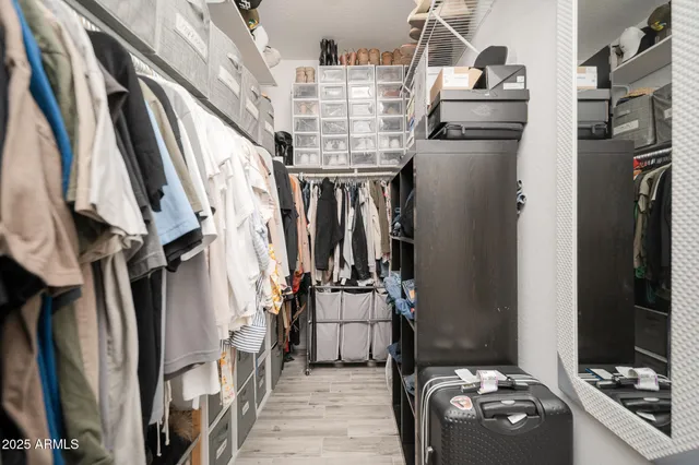 a view of walk in closet with clothes and shoes