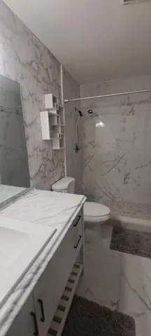 a bathroom with a granite countertop sink a toilet and shower