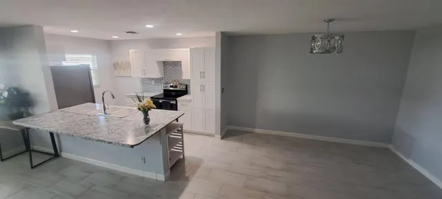 a kitchen with stainless steel appliances granite countertop a sink and a refrigerator