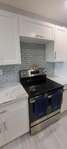 a stove top oven sitting inside of a kitchen