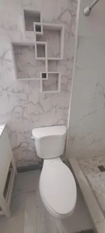 a bathroom with a toilet and a shower