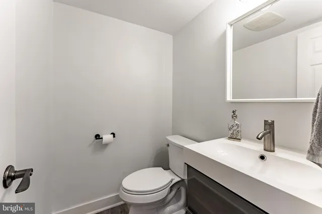 a bathroom with a sink mirror and toilet