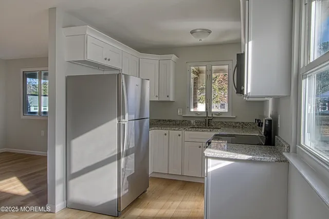 a kitchen with granite countertop a refrigerator and a sink