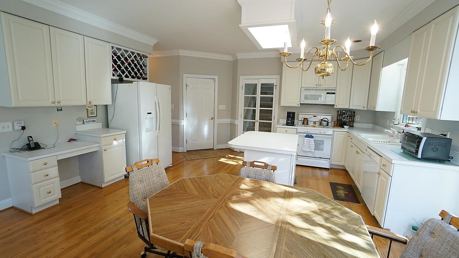 2701 Rydal Court Raleigh, NC 27613 - Photo 9 of 29 Large kitchen with built-in desk and wine rack. Prep island and french doors to back stairs which access bonus room. Kitchen