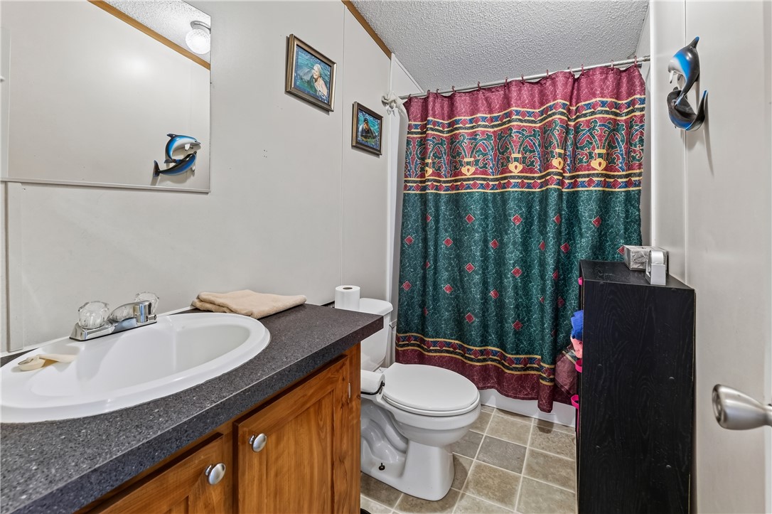1905 Bethany Church Road Belton, SC 29627 - Photo 16 of 20 Functional layout elements define this cozy restroom featuring wood cabinetry and tiled flooring.