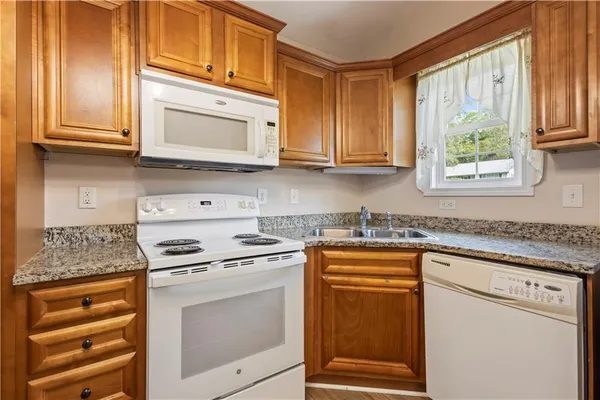 a kitchen with stainless steel appliances granite countertop a stove a sink and a microwave