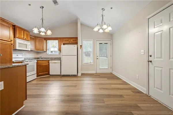 a view of a kitchen with granite countertop stainless steel appliances and a chandelier