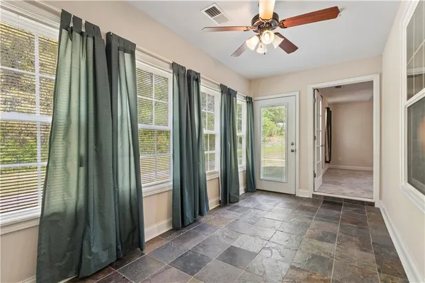 a view of a hallway with a chandelier fan and windows
