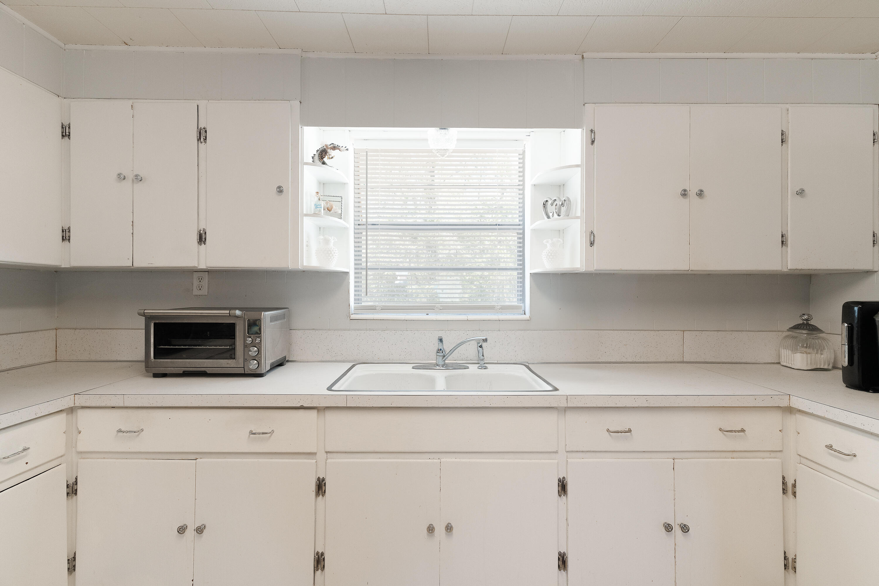 5686 Griffith Cemetery Road Baker, FL 32531 - Photo 16 of 52 a kitchen with granite countertop white cabinets and a window