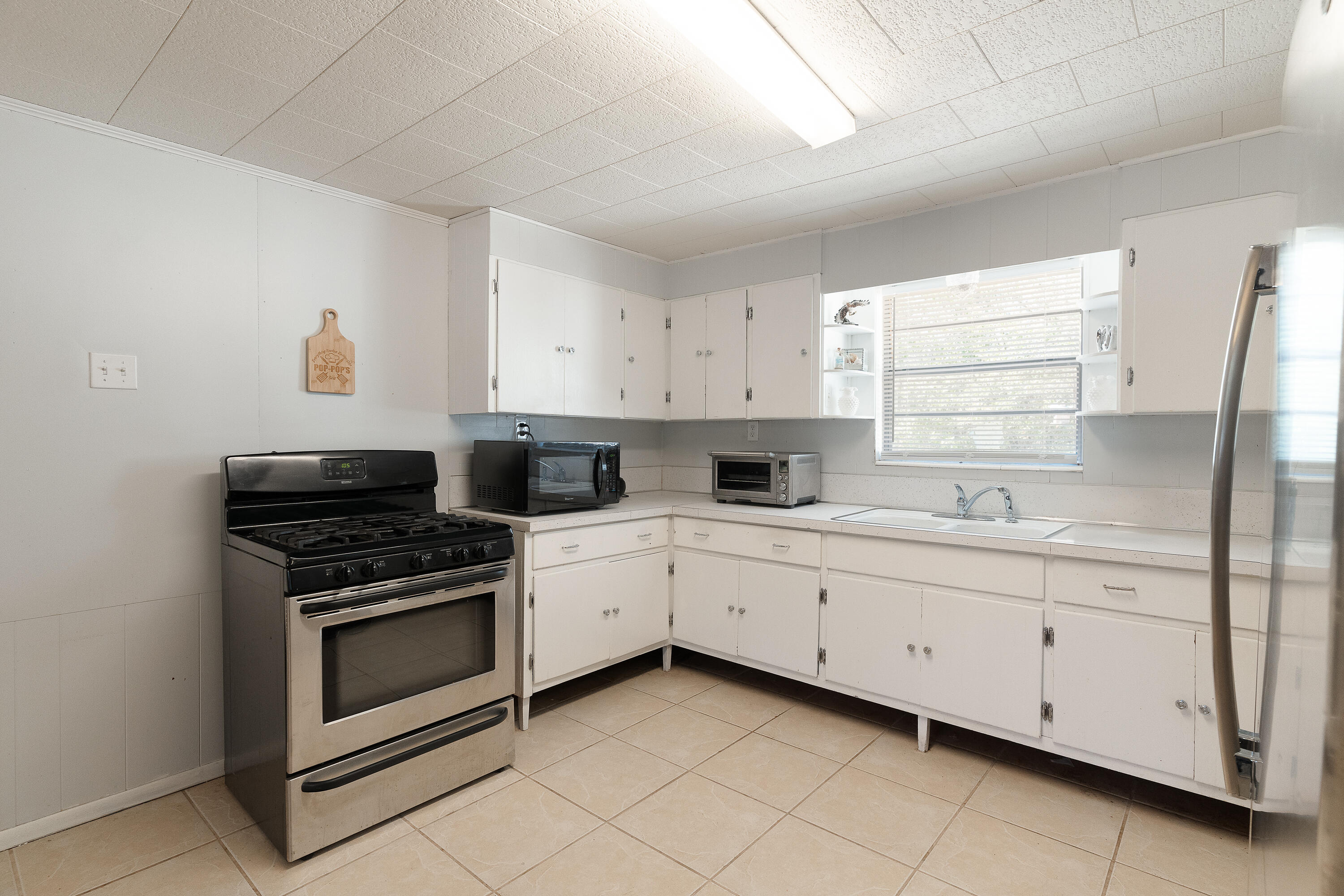 5686 Griffith Cemetery Road Baker, FL 32531 - Photo 17 of 52 a kitchen with cabinets appliances and a window