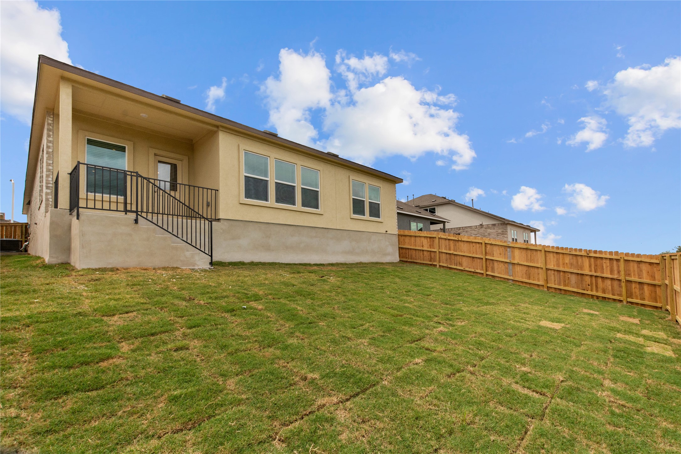 1108 Mallow Road Leander, TX 78641 - Photo 21 of 30 A wooden privacy fence borders the grassy yard and elevated rear patio.