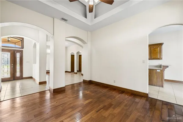 a view of a hallway with wooden floor and a kitchen