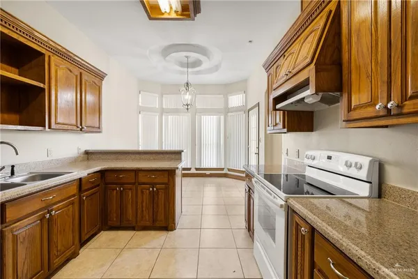 a kitchen with stainless steel appliances granite countertop a sink and a stove