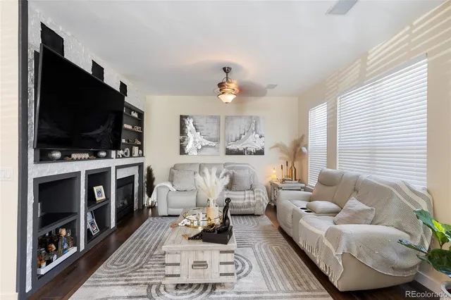 a living room with furniture a flat screen tv and kitchen view