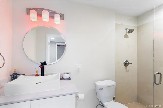 a bathroom with a sink mirror and toilet