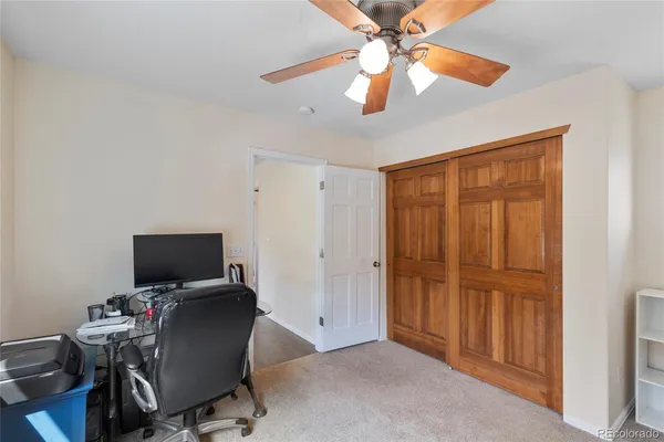 a view of a workspace with furniture and a window