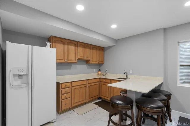 a kitchen with a sink a refrigerator and chairs