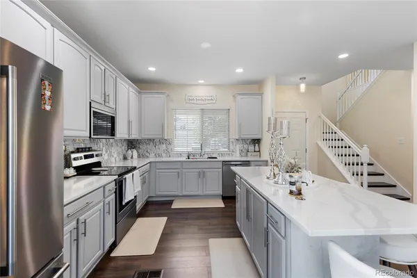 a kitchen with a sink stove cabinets and refrigerator