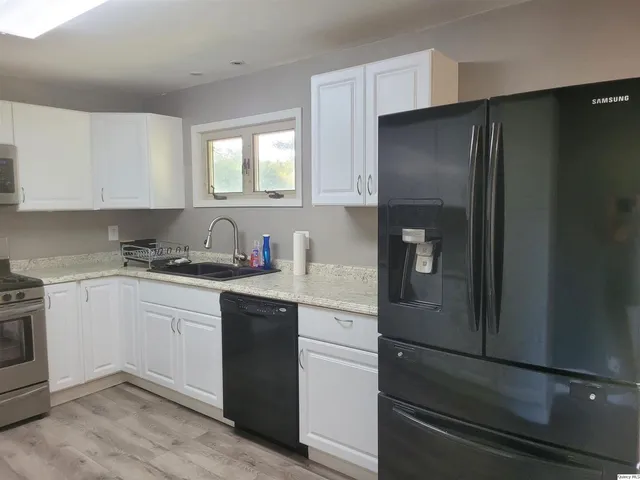 a kitchen with a refrigerator and white cabinets