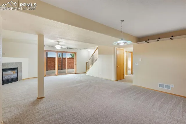 a view of an empty room with a fireplace and a window