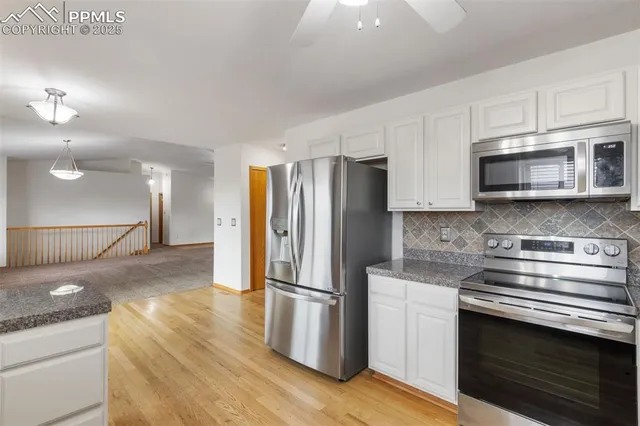 a kitchen with stainless steel appliances granite countertop a refrigerator stove and microwave