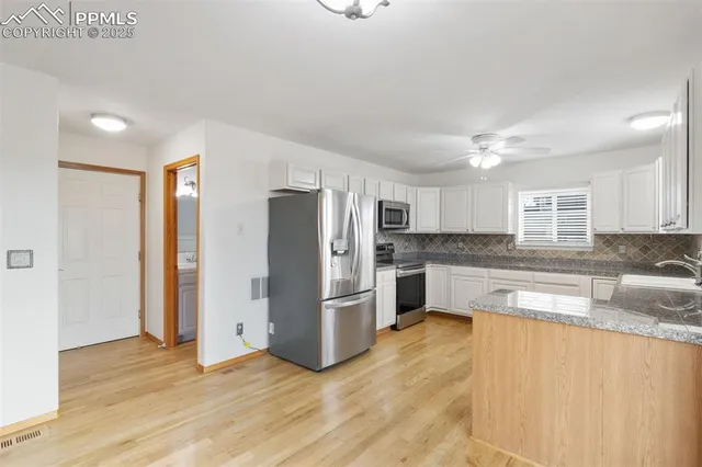 a kitchen with stainless steel appliances granite countertop a refrigerator a sink and a stove