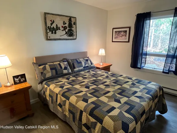 a bedroom with a bed and painting on the wall