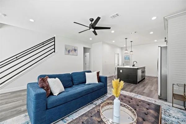 a living room with furniture a rug and kitchen view