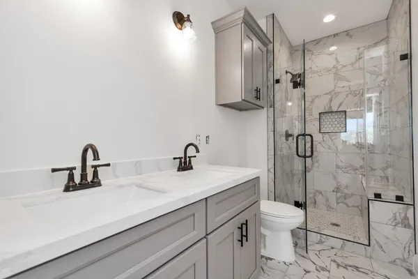 a bathroom with a sink a toilet and shower