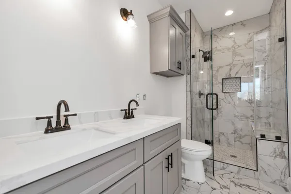 a bathroom with a sink a toilet and shower