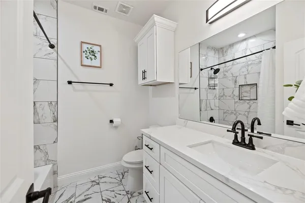a bathroom with a sink a toilet and shower