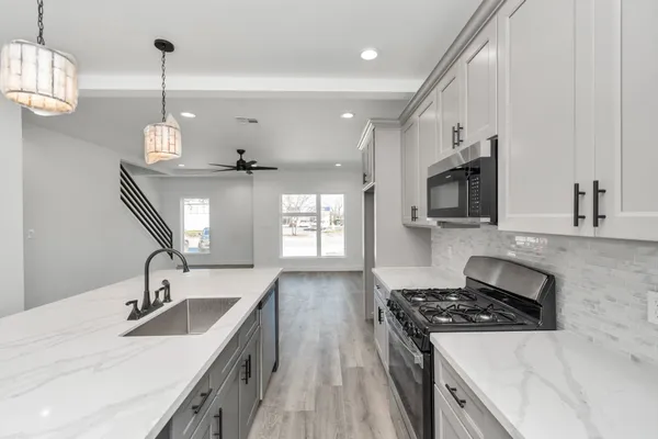 a kitchen with stainless steel appliances granite countertop a sink stove and refrigerator